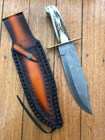 Detailed craftsmanship of the Western Bowie knife’s antler horn handle and polished brass guard.